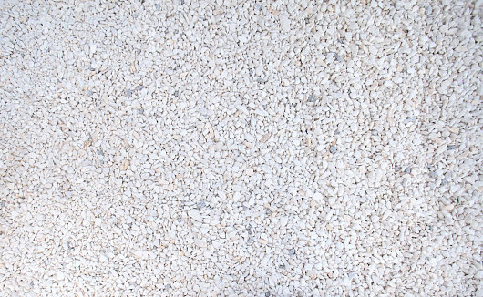 Top shot of white Pebble beach texture. Neutral monochrome nature background.