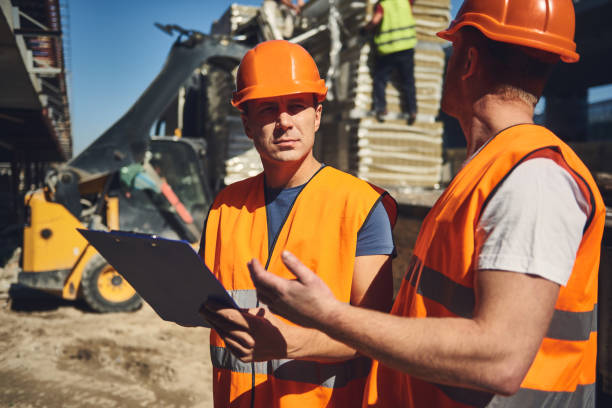 istock Thoughtful builder frowning and looking at his colleague 1092688444