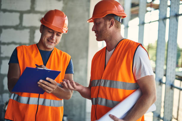 istock Positive builder making notes and talking to his coworker 1092688468