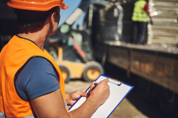 istock Professional foreman standing with clipboard and looking at the building process 1092688480