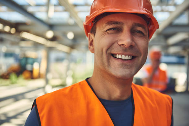 istock Smiling adult builder is locating at the construction site 1092688524