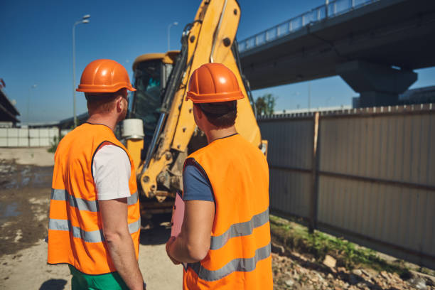 istock Two builders in helmets are working outdoor 1092688544