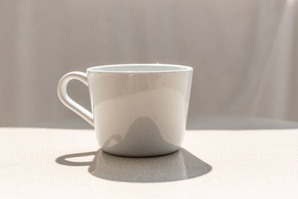istock White ceramic coffee cup on white ceramic table, outdoor on sunny day with cup's shadow on table 1092689900