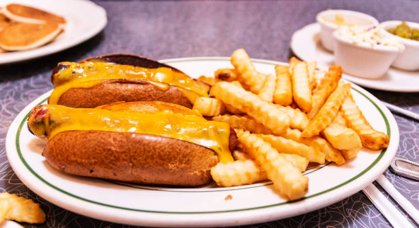 istock Two hot dogs with cheese on a plate with fries 1092694488