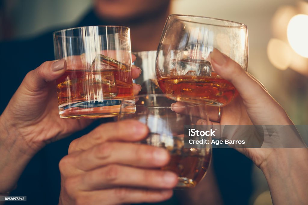 Trois personnes fait un toast avec du whisky - Photo de Trinquer libre de droits