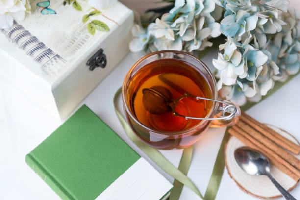 istock black tea mug, green cover book, cinnamon sticks, box, teaspoon, hydrangea flowers, ribbon, 1092697416