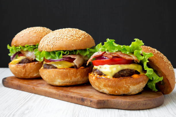 istock Cheeseburgers on rustic wooden board, side view. Close-up. 1092697828