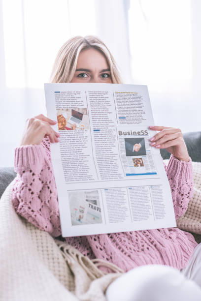 istock woman reading business newspaper while sitting at home 1092699072