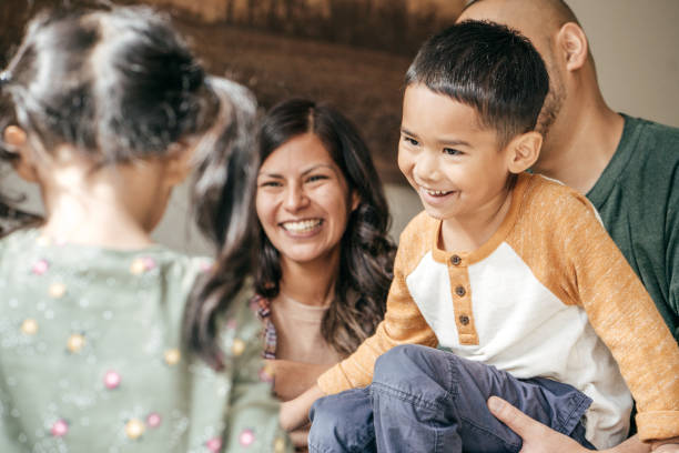 Laughing family with two kids Hispanic Family laughing together happy filipino family stock pictures, royalty-free photos & images