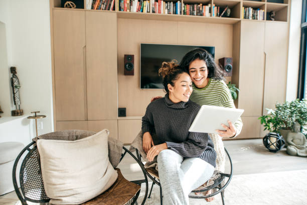 istock Two female friends laughing looking at tablet 1092703816