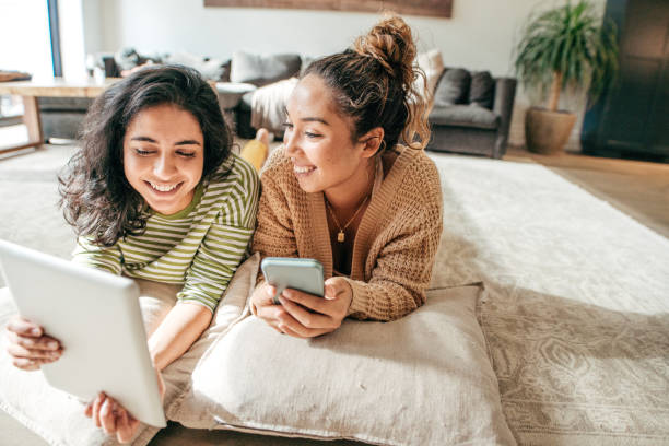 Social media for students and academic success Two female students with digital tablet and cellphone at home gen z stock pictures, royalty-free photos & images