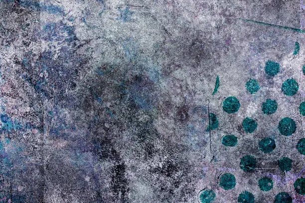 Gray, purple, blue and black grunge abstract background with some painted teal polkadots in the lower right corner.