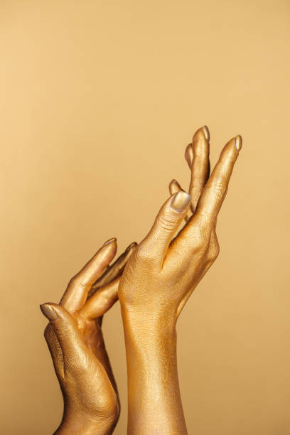 istock partial view of female painted hands on golden background 1092706830
