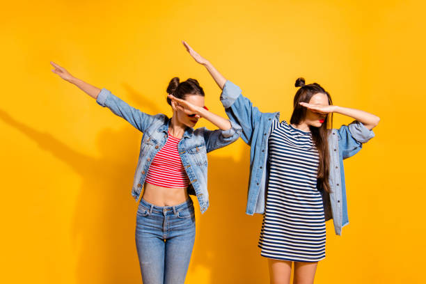 Two nice-looking good-dressed cute sweet gorgeous brunette hair lady stand isolated on yellow wall make dabbing movement Two nice-looking good-dressed cute sweet gorgeous brunette hair lady stand isolated on yellow wall make dabbing movement dab dance photos stock pictures, royalty-free photos & images