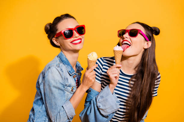 Two brunette hair lady isolated on yellow vivid background in glasses spectacles make beaming white toothy smile eating sugar tasty appetiser snack Two brunette hair lady isolated on yellow vivid background in glasses spectacles make beaming white toothy smile eating sugar tasty appetiser snack appetiser stock pictures, royalty-free photos & images