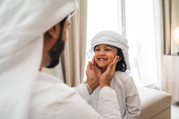 Arab man fixing keffiyeh to his son