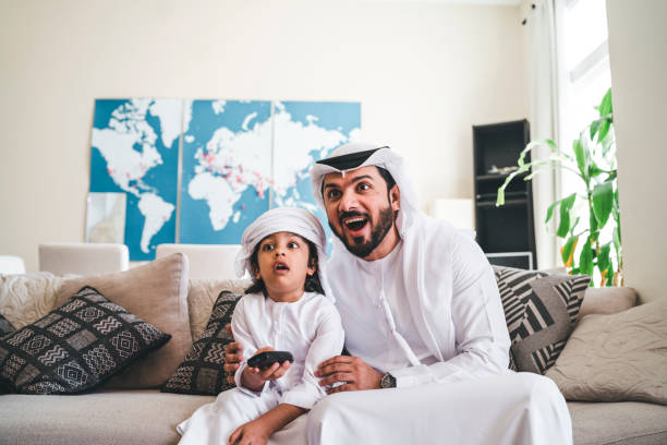 istock Arab man looking TV at home with his son 1092713368