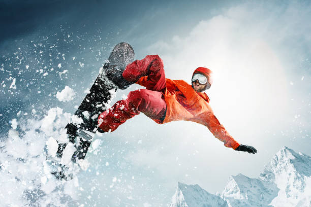 snowboarder salta a través del aire con el cielo azul de fondo - saltar actividad física fotos fotografías e imágenes de stock