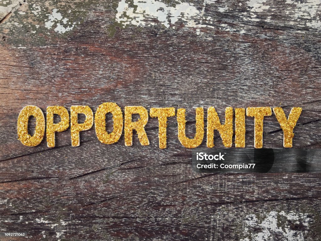 Motivational and inspirational word. Word ‘OPPORTUNITY’ in gold color letters arranged on a wooden table. Opportunity Stock Photo