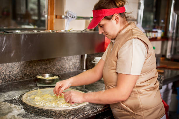 cook spreading sour cream and cheese over pizza dough - wheat pasta flour italy imagens e fotografias de stock