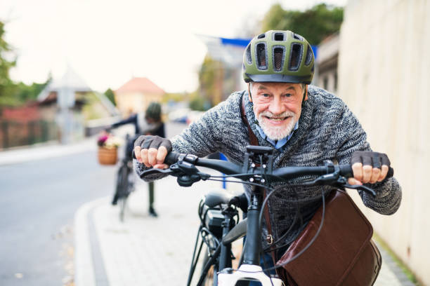istock Active senior couple with electrobikes standing outdoors on a road in town. 1092724748