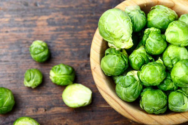 istock fresh organic brussels sprouts raw in a plate on wooden background. 1092735604