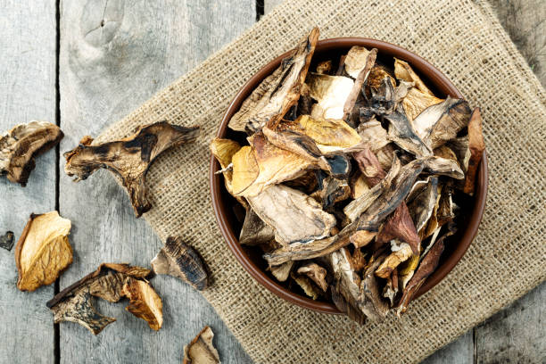 istock dried mushrooms on a wooden background on burlap. 1092736440