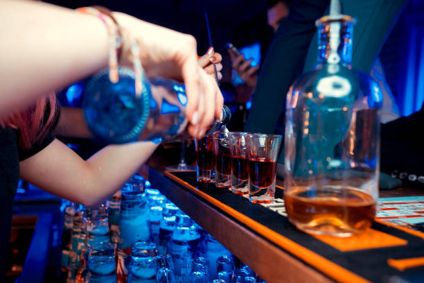 istock Bartender pours alcoholic drink into small glasses on bar 1092740556