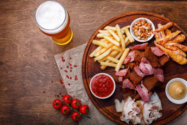 gran conjunto de bocadillos para cerveza o alcohol e incluye carne de cerdo ahumado, papas fritas, pan frito, palitos de cangrejo y frutos secos - beer nuts fotos fotografías e imágenes de stock