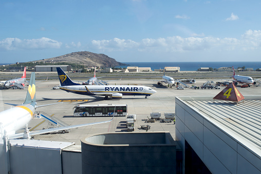 View from the tourist departure terrace on the flat roof airport building. Side view on Airplane Boeing 737 from Ryanair on the ground ready for departure.