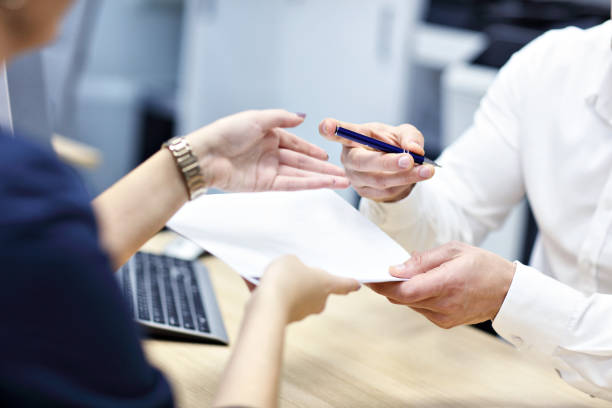 istock Midsection of hands holding documents and pen 1092757414