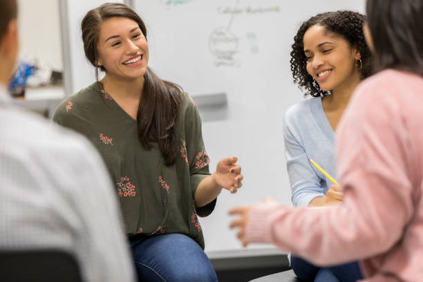 High school students discuss group project Hispanic female high school student brainstorms with a group of students. They are suggesting ideas for a group project. high school student classroom education student stock pictures, royalty-free photos & images