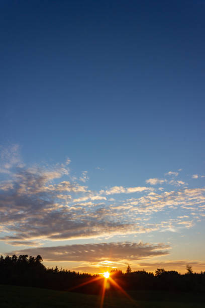 istock blue sky sunset with sunbeams at south german countryside 1092767108