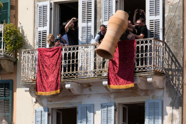 corfians jogar potes de argila de janelas e varandas no sábado santo, para celebrar a ressurreição de cristo. pote de páscoa sensacional - jug water pottery clay - fotografias e filmes do acervo