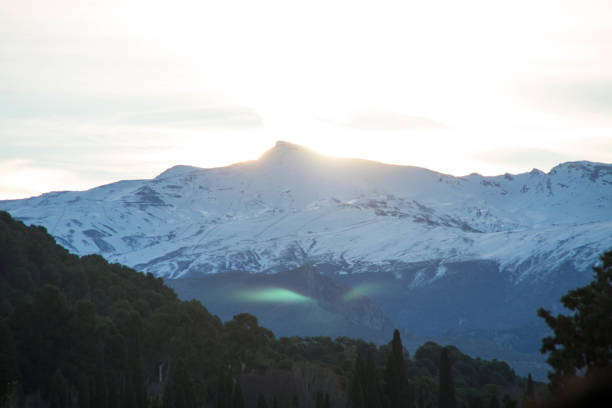 Green light phenomena during sunrise above Sierra Nevada snowy mountain. Granada, Spain.