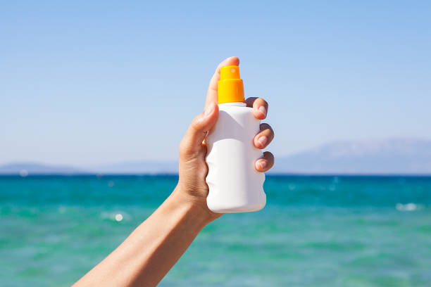 istock Woman is holding sunscreen on a beach on a sunny day. 1092779814