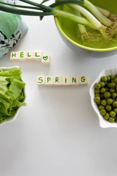 Fresh raw spring vegetables on white background, text " Hello spring"
