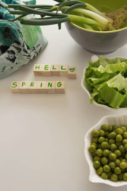 Fresh raw spring vegetables on white background, text " Hello spring"