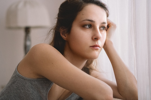 Depressed woman has sad and lonely feel sitting on the bed
