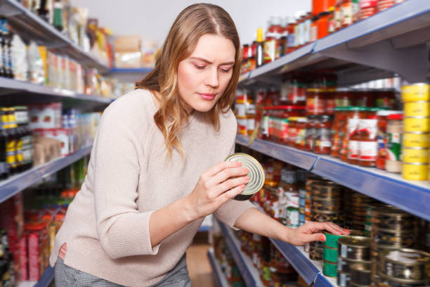 istock Glad female in the shop holding preserved  fish 1092803534