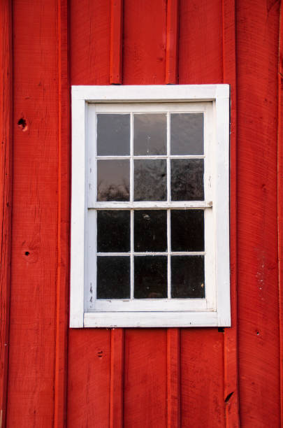 White Framed Window in Red Barn Siding A single white framed window in bright red barn siding. red barn house stock pictures, royalty-free photos & images