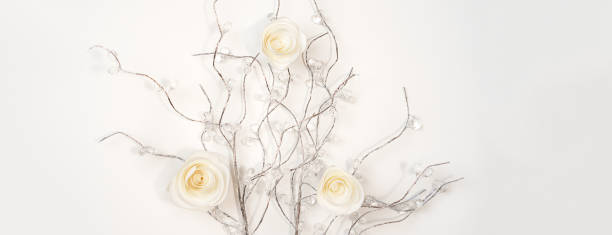 istock White paper Roses on silver branches on white background. Flat lay, top view. Valentine's Day background, horizontal 1092814196