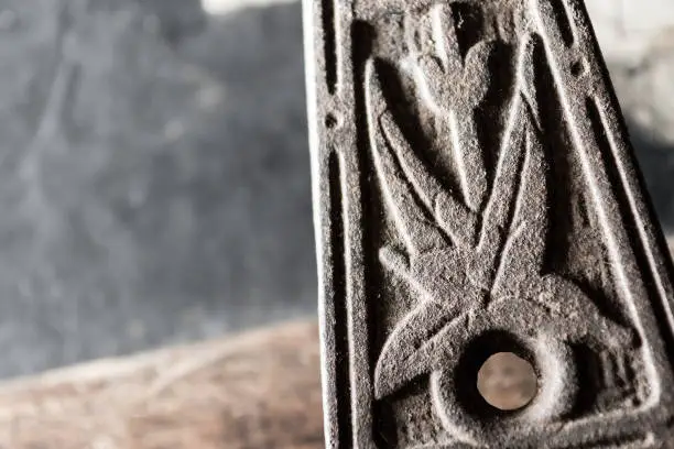 Photo of Close up of the floral decoration on the handle of an iron trivet for a smoothing iron