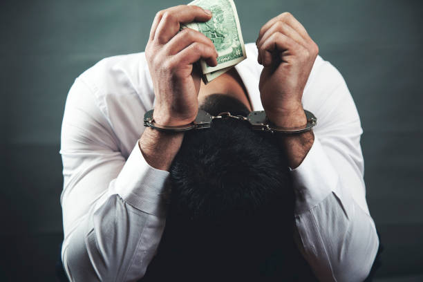 istock sad man hand handcuffs with money 1092831630