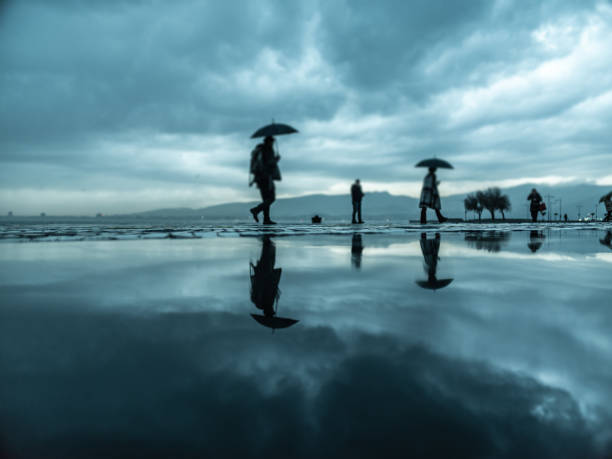 People walking under the rain in the rainy day stock photo