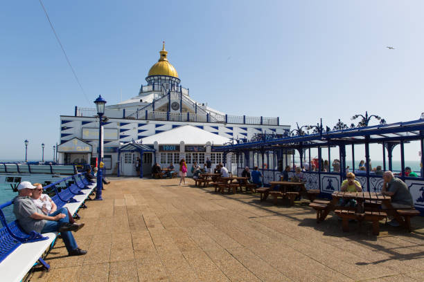 Tourists and visitors on Eastbourne Pier, East Sussex, on Sunday 22nd April 2018 Tourists and visitors enjoying Eastbourne Pier in the beautiful spring weather, Eastbourne, East Sussex, on Sunday 22nd April 2018 22nd april stock pictures, royalty-free photos & images