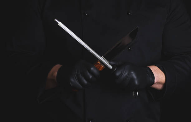 istock cook in black latex gloves sharpens a knife 1092858624
