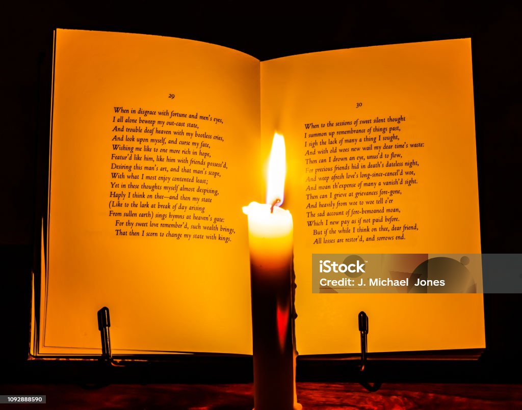 Open book of Shakespeare A book of Shakespeare's sonnets open to nos. 29-30, lit by a burning taper candle. William Shakespeare Stock Photo