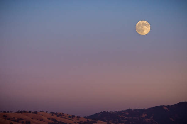 istock Full moon rising over a mountain ridge, California 1092889054