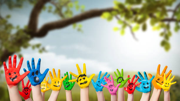 colorful painted hands in front of a spring scene colorful painted hands in front of a spring scene preschool photos stock pictures, royalty-free photos & images